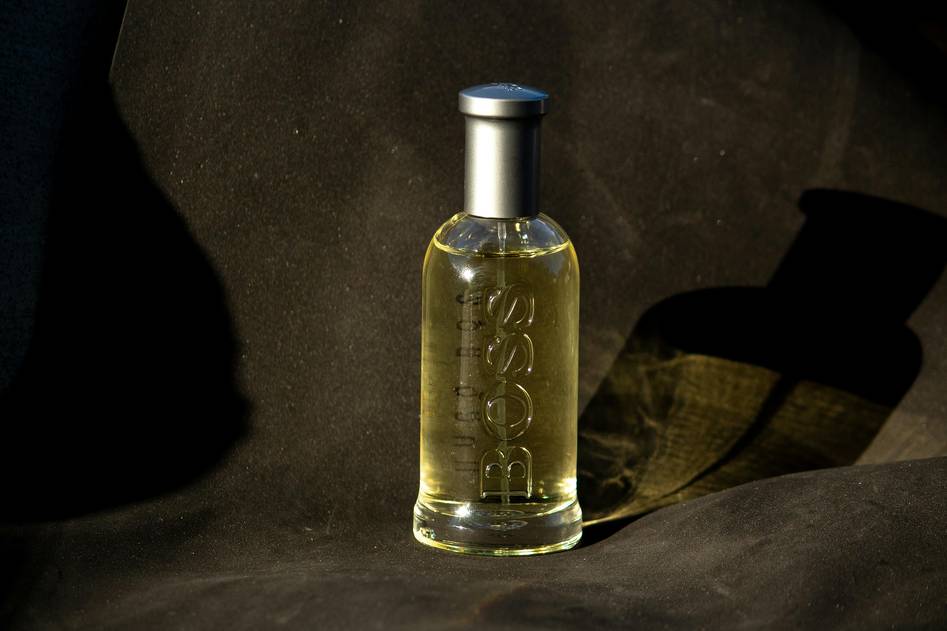Close-up of a man applying aftershave lotion with a calming bathroom background